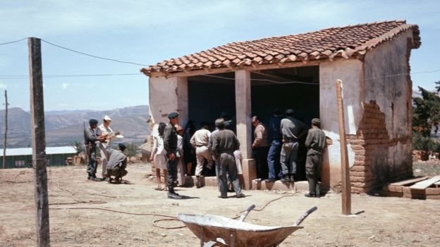 Soldados, periodistas y pobladores de Vallegrande en el lugar donde el Che era exhibido el 10 de octubre de 1967 | GETTY IMAGES