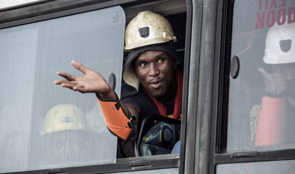 Uno de los trabajadores rescatados en Sudáfrica saluda tras salir de la mina