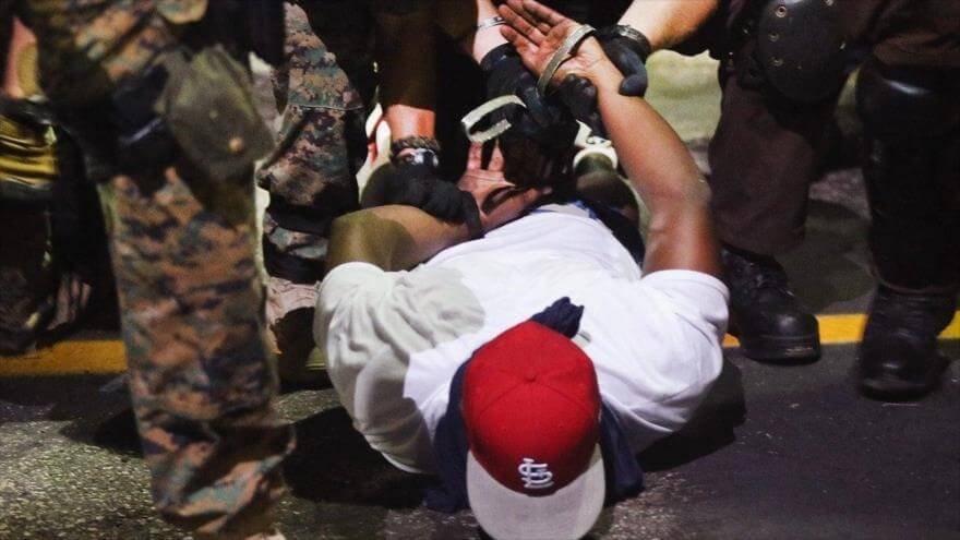 Policias de EE.UU. detienen a un manifestante durante protestas contra la discriminación