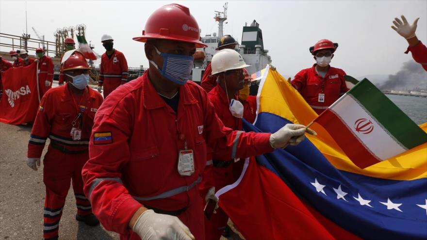 Un trabajador petrolero venezolano sostiene una pequeña bandera irani en la Refineria el Palito Venezuela