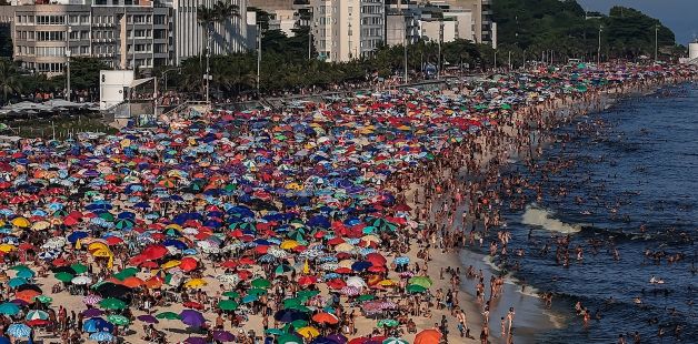 Cientos de personas acuden a la playa de Ipanema este domingo en Río de Janeiro para combatir el calor.