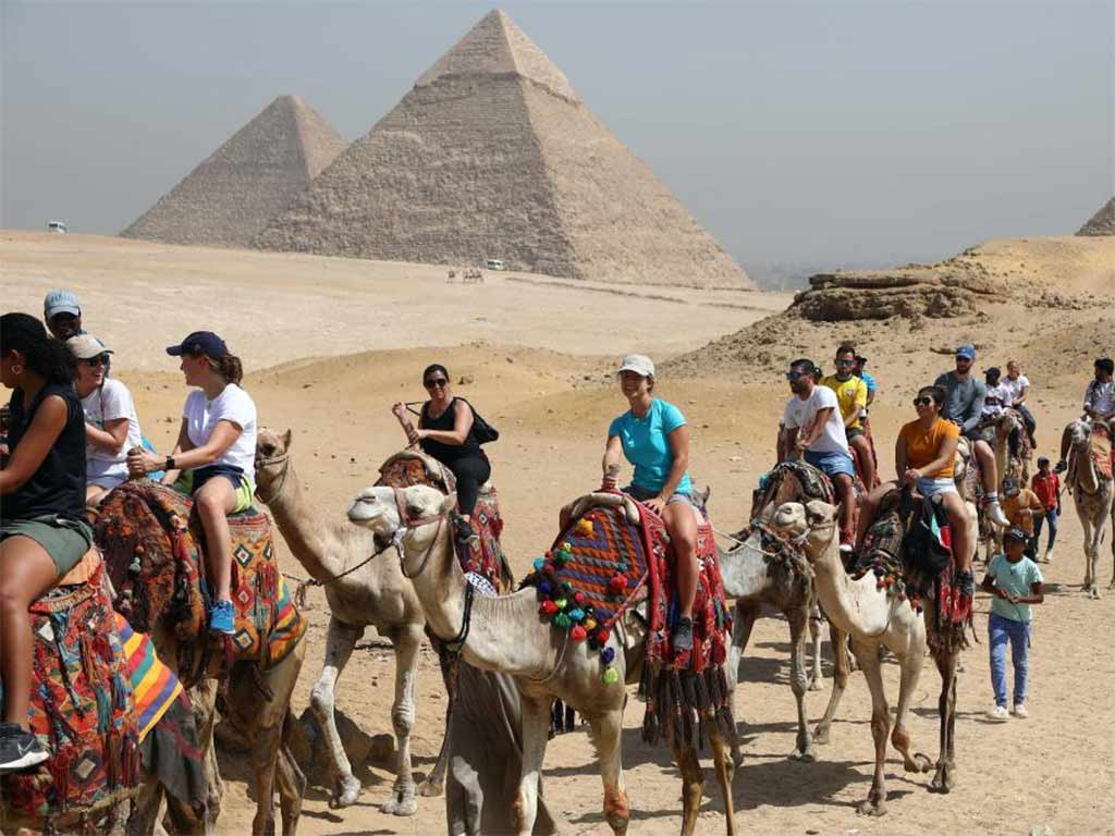 Turistas en Egipto en paseo al aire libre cercanos a las Pirámides de Giza