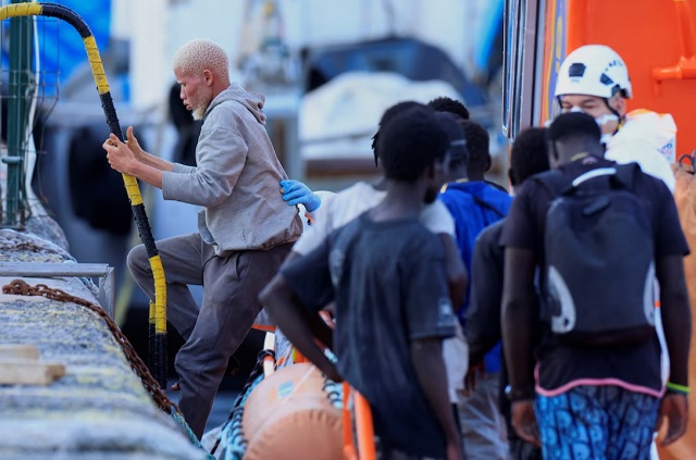 Varios migrantes esperan desembarcar de una embarcación de madera en el puerto de Arguineguín, en la isla de Gran Canaria. España. | Foto: REUTERS/Borja Suárez 