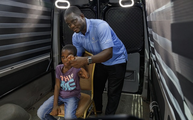 Rita Zaansuma-Naporo, de 9 años, acompañada de su padre, asiste a la primera prueba en vivo de la tecnología de telemedicina 3D 