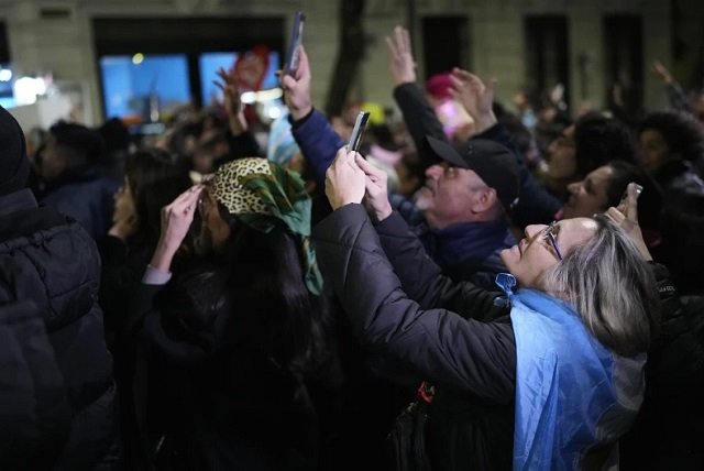 Partidarios de la expresidenta Cristina Fernández le toman fotos en el balcón de su casa, donde cumple una condena de seis años de arresto domiciliario por corrupción, tras el cierre de las elecciones provinciales legislativas, en Buenos Aires, Argentina, el domingo 7 de septiembre de 2025. (Foto AP/Natacha Pisarenko)