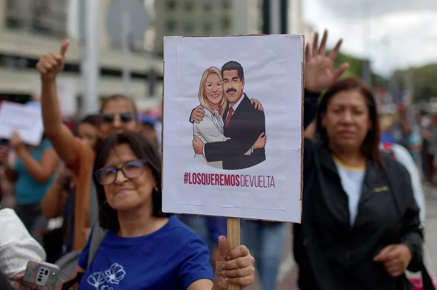 Una persona sostiene un cartel con la imagen del presidente de Venezuela, Nicolás Maduro, y su esposa Cilia Flores durante una marcha en Caracas (Venezuela). EFE/ Miguel Gutiérrez