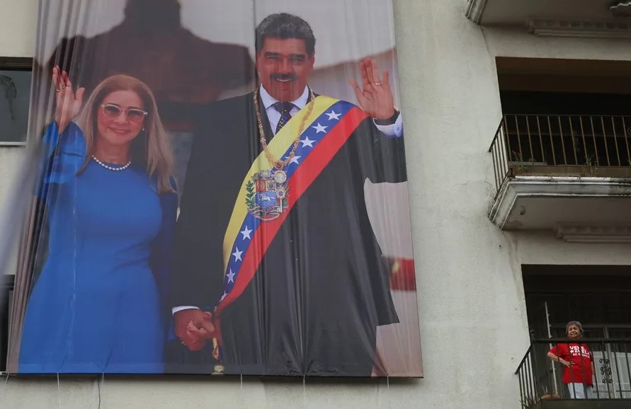 Una persona sostiene un cartel con la imagen del presidente de Venezuela, Nicolás Maduro, y su esposa Cilia Flores durante una marcha en Caracas (Venezuela). EFE/ Miguel Gutiérrez