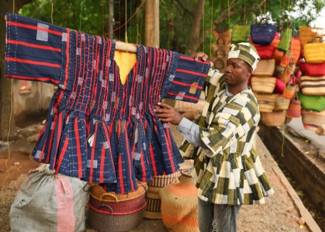  Clement Azaabire cuelga prendas tradicionales de fugu bajo un árbol. / Foto: Foto AP / Tsraha Yaw
