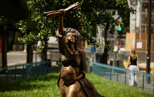 El artista francés Didier Audrat fotografió en París, el miércoles 27 de mayo de 2026, una estatua que conmemora la abolición de la esclavitud y representa a Solitude, hija de una esclava africana violada por un marinero a bordo del barco que la transportaba al Caribe, sosteniendo la proclama de Louis Delgrès, líder de la resistencia antiesclavista que clamaba por la resistencia y la lucha. (Foto AP/Tomás Padilla)
