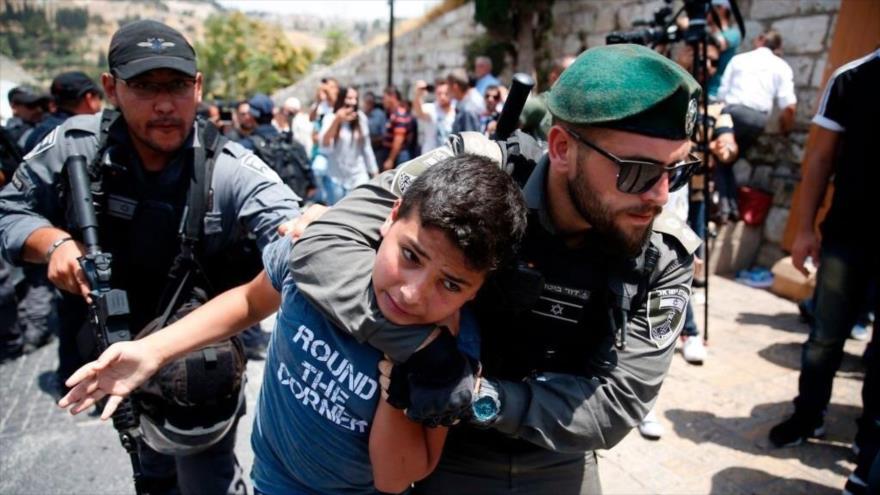 Los guardias fronterizos israelíes detienen a un joven palestino durante una manifestación acerca de la mezquita de Al Aqsa