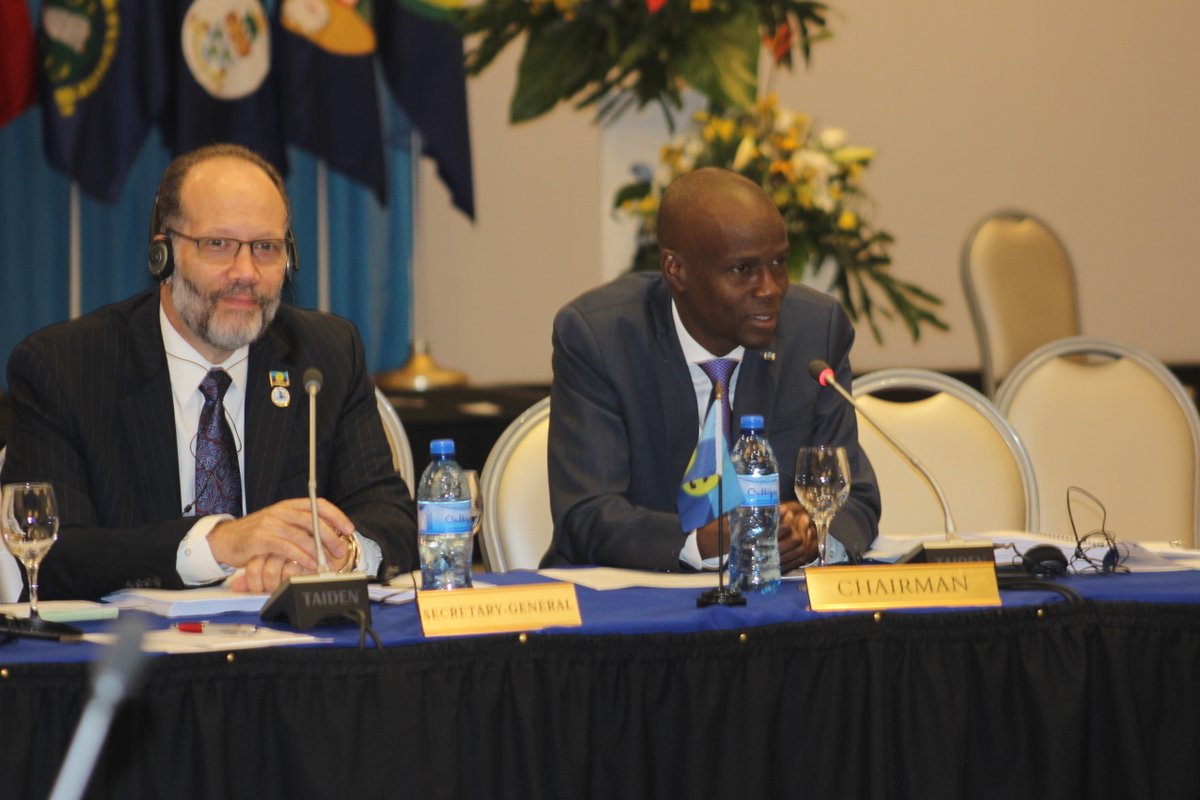 El presidente Jovenel Moise de Haití y el Secretario General, el Embajador Irwin LaRocque en la mesa principal